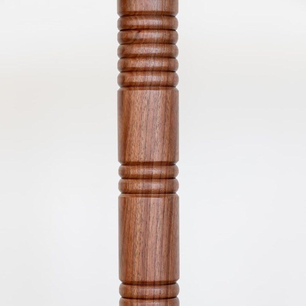 This elegant and versatile wooden drink table is a beautiful addition to any home or commercial space. The circular tabletop is crafted from high-quality walnut wood, showcasing its natural grain and warm tones. The unique, intricately carved ribbed detailing on the central support adds a touch of artistry and visual interest. This table is perfect for serving drinks, snacks, or displaying decorative items